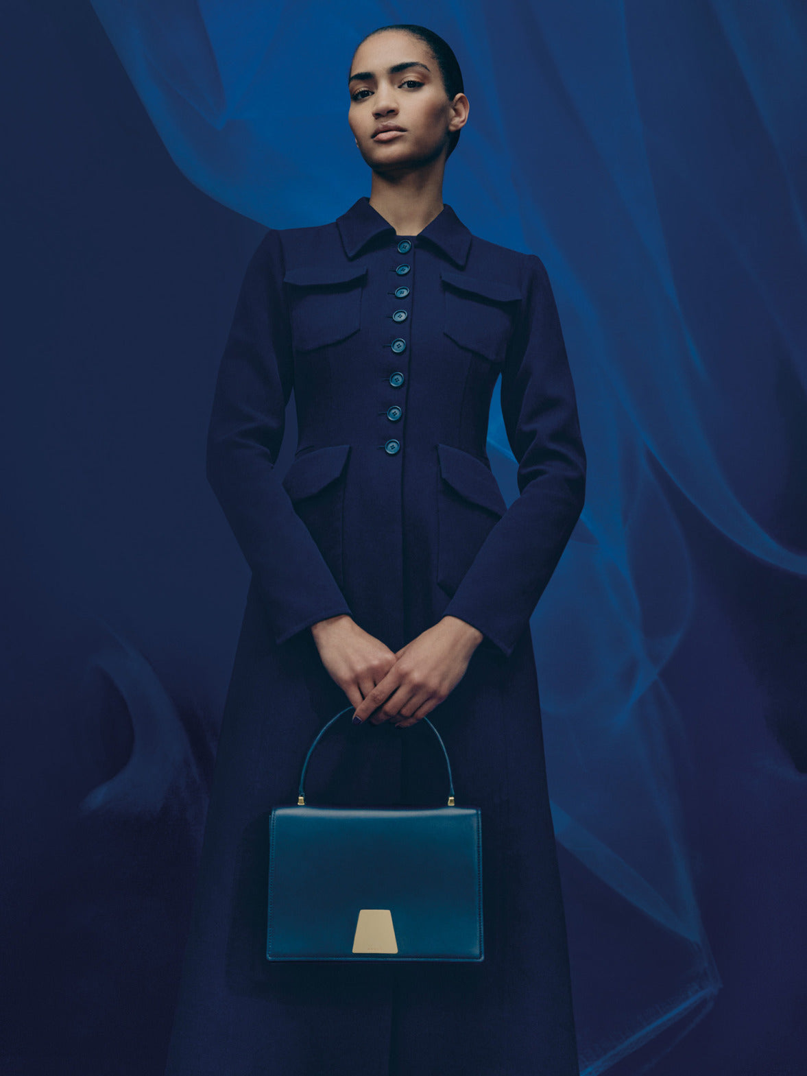 Akris FW 2025 collection distills the magic of the blue hour into wearable form. Tailored coats, feather skirts, and softly structured dresses define the silhouette. 