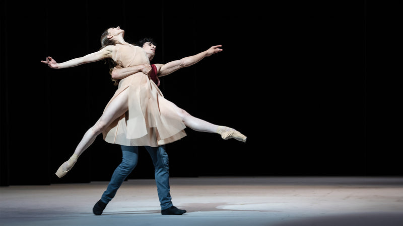 Hamburger Ballet Epilogue - Ballerina, dressed in a bright Akris dress, seems to float across the stage, supported in the arms of a ballerino.