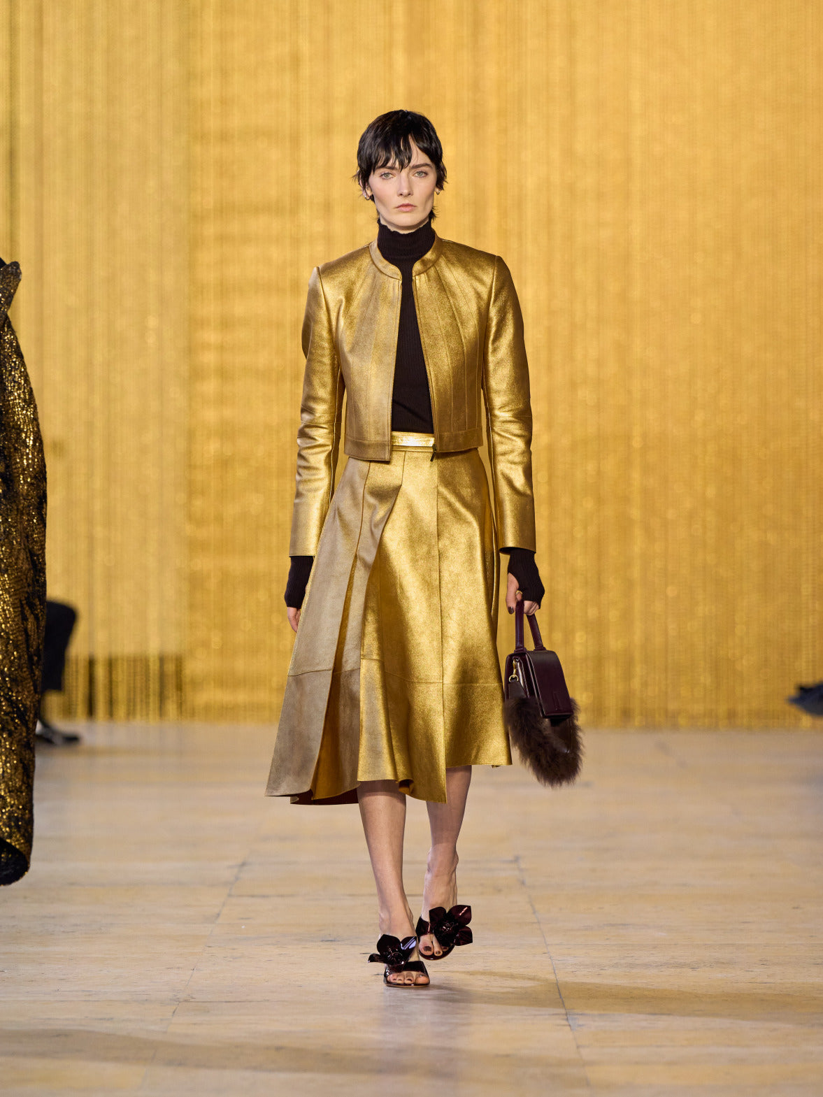 A tribute to Olga de Amaral in the Akris FW26 collection in Paris, defined by a dialogue between deep blacks, burgundy, and metallic gold accents