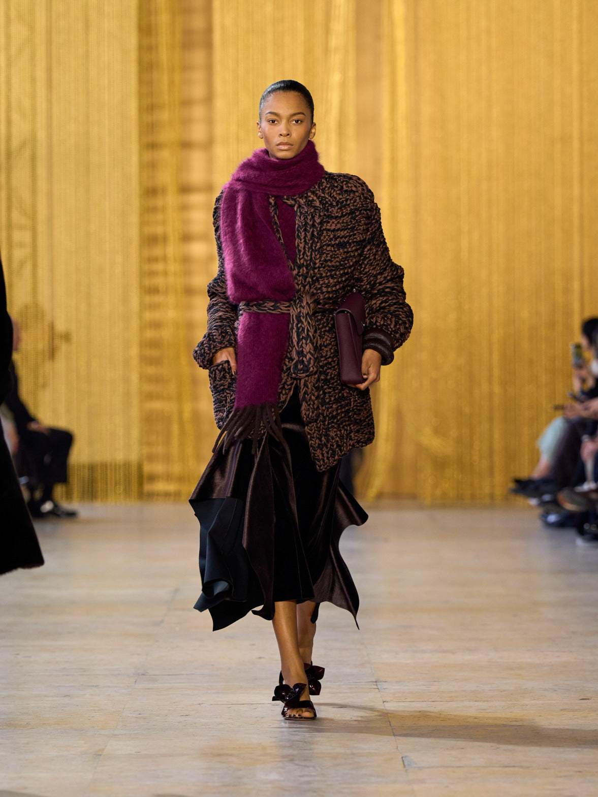A tribute to Olga de Amaral in the Akris FW26 collection in Paris, defined by a dialogue between deep blacks, burgundy, and metallic gold accents
