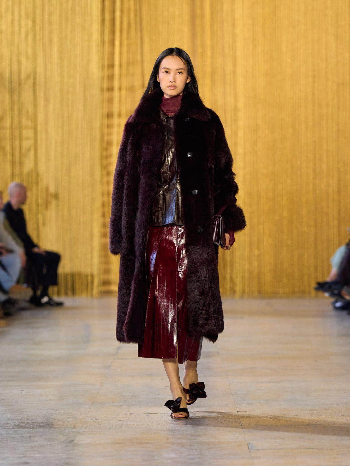 A tribute to Olga de Amaral in the Akris FW26 collection in Paris, defined by a dialogue between deep blacks, burgundy, and metallic gold accents