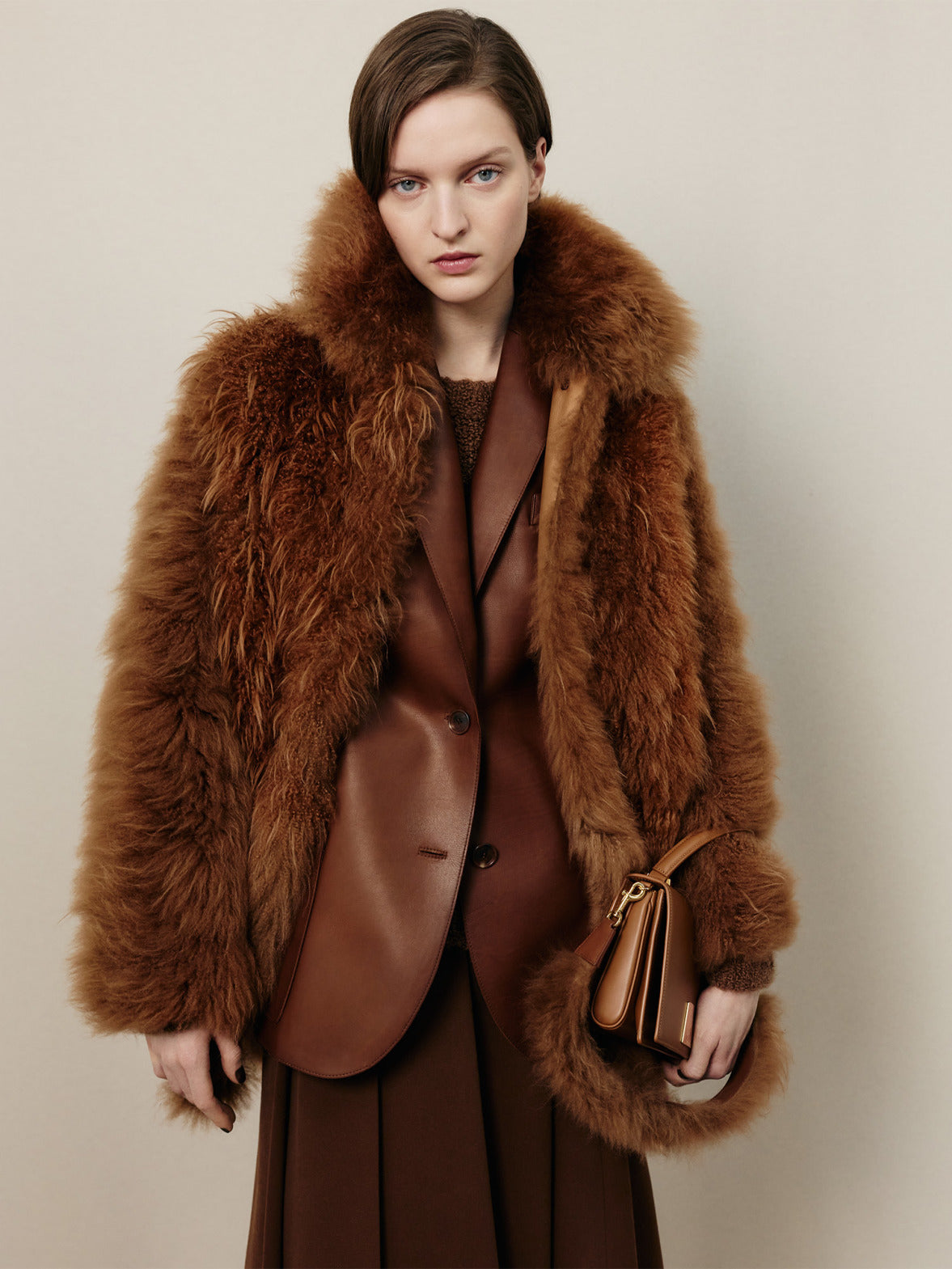 Akris Fall 2026 collection featuring a brown fur coat, leather layers and the Alice Top Handle Bag in warm autumnal tones.
