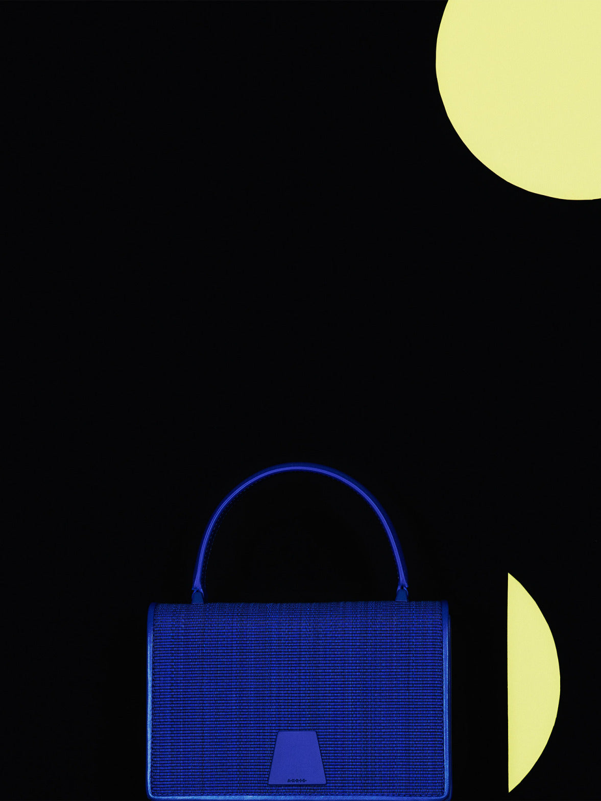 Akris Alice handbag in blue horsehair featuring a structured top handle, set against a black background.