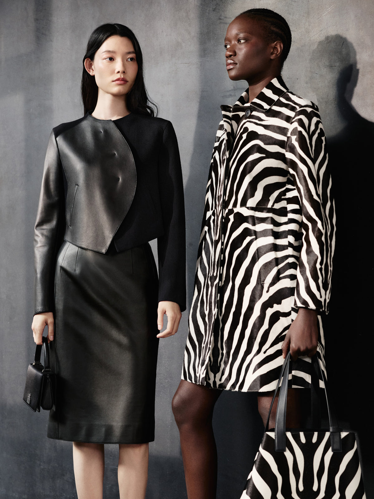 Explore the striking contrasts of the Akris Pre-Fall collection, featuring a structural black leather jacket and skirt set alongside a bold, full-length zebra print coat. Complete your style with the coordinating luxury handbags, including the iconic Ai tote and the elegant Anouk. Discover exquisite Swiss tailoring designed for modern elegance.