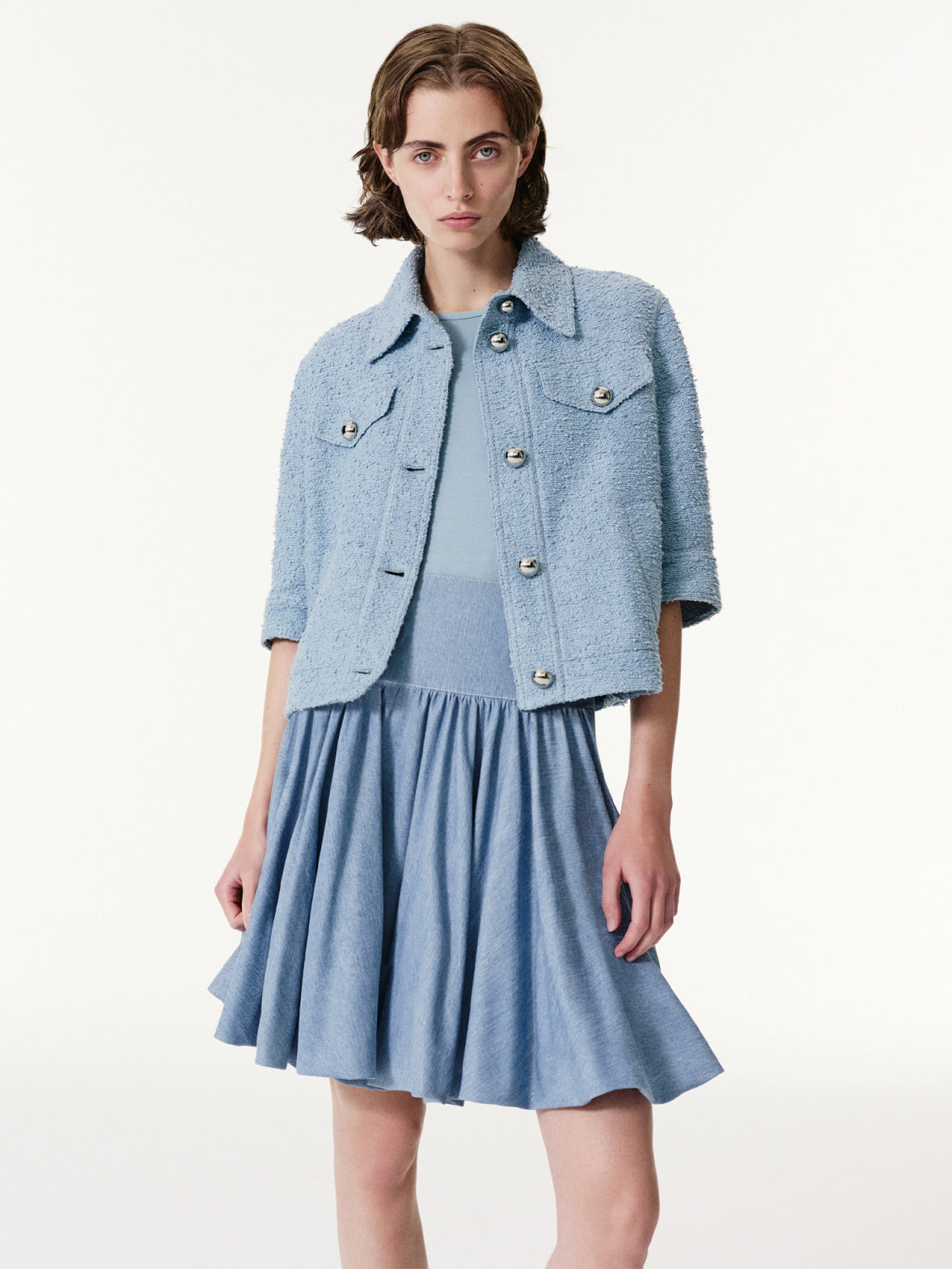 Akris Punto Spring/Summer denim look featuring a light blue textured cropped jacket with matching fluid dress, combining casual elegance with modern tailoring.
Contemporary denim styling with soft structure, clean lines, and refined minimalist design.