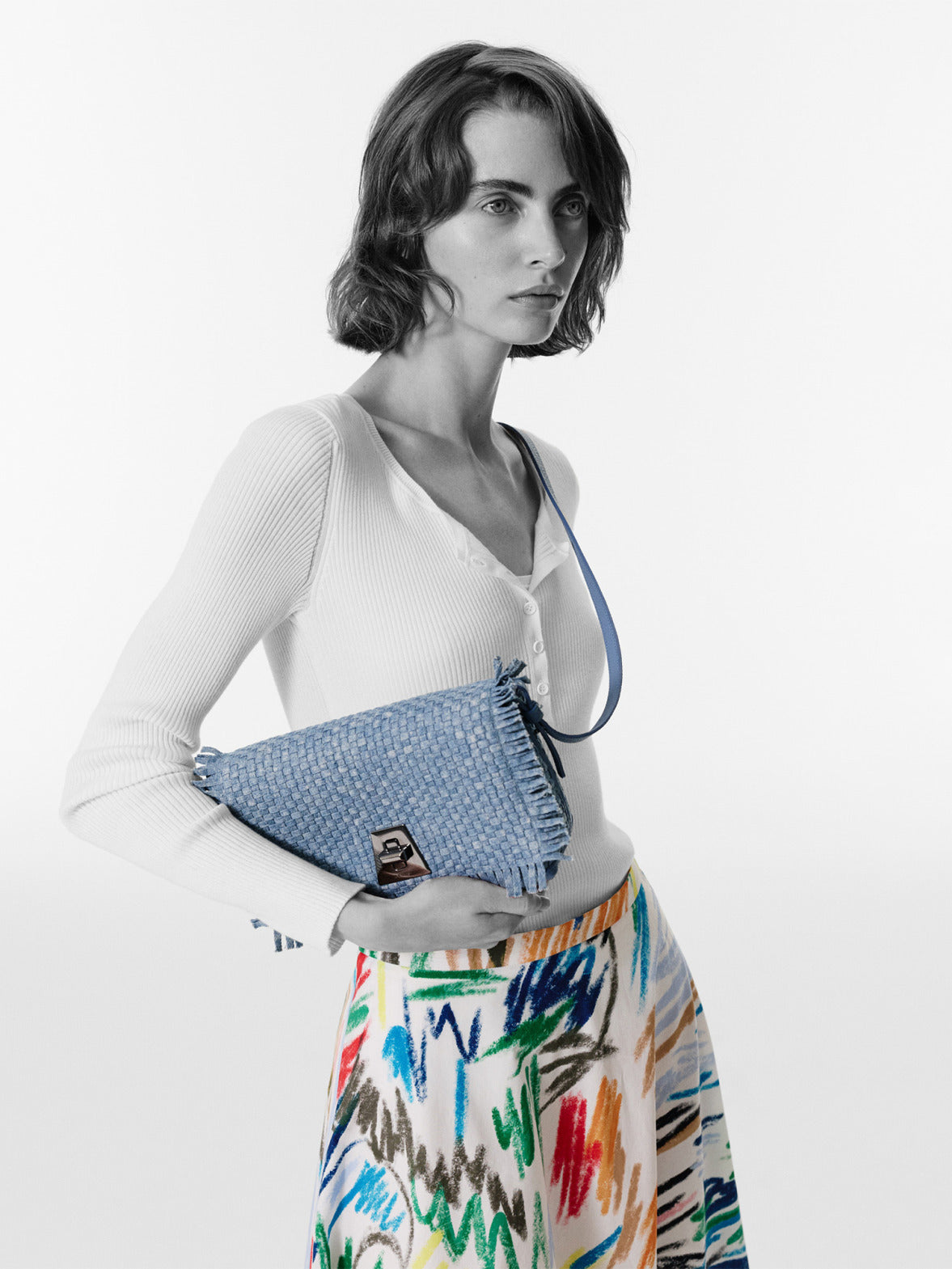 Discover the exquisite artistry of the Akris Spring collection, highlighting the sophisticated Anouk clutch bag featuring an intricate, colorful embroidered design. Seamlessly paired with a vibrant, matching pattern dress, this luxury accessory captures a perfect balance of bold creative texture and sleek silhouettes. Experience timeless Swiss refinement.