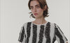 Discover the artistic energy of the Akris punto Spring collection, celebrating playful movement and the vibrant scribble print. From colorful patterned skirts and jumpsuits to bold black-and-white graphic coordinates and striking orange totes, these pieces bring creative expression to life. Experience joyful, modern luxury and exquisite Swiss design.
